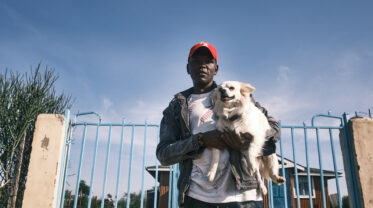 Ein Mann hält einen kleinen Hund auf dem Arm